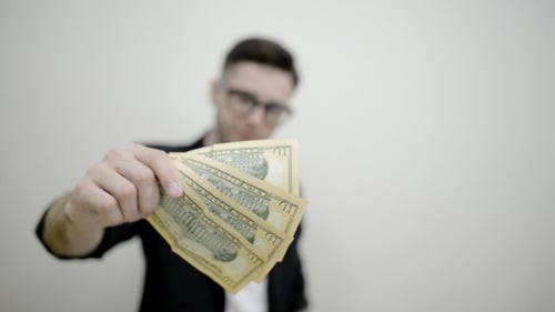 Young Adult Shows Money in Office Environment