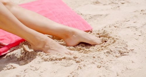 Close Up Woman Feet Resting On Beach Sand