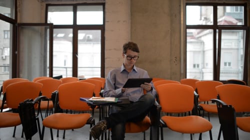 Young Adult Working on Tablet in Empty Lecture Hall