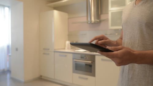 Man Using Tablet in Modern Kitchen