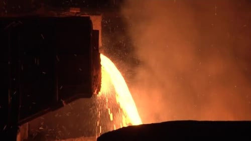 Flüssiges Metall gießt in das Gefäß Orange Metal