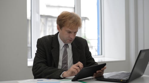 Businessman Typing on Tablet