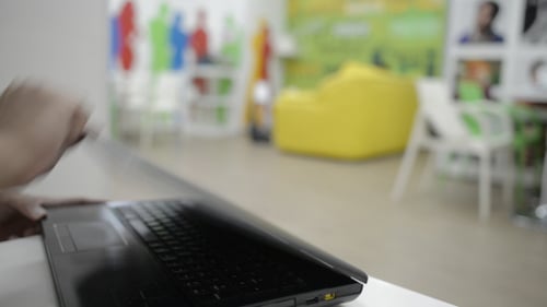 Opening Laptop and Typing in Modern Office