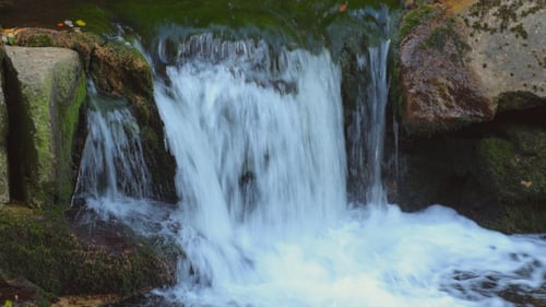 Small Waterfall Cascading Over Mossy Rocks
