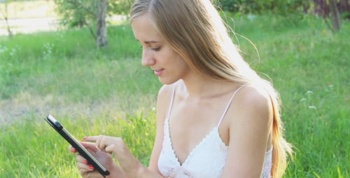 Lovely Girl Using a Tablet in the Park