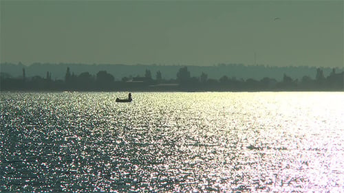 A Fisherman in a Boat at Night