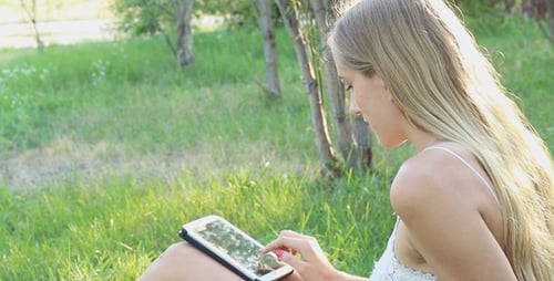 Beautiful Girl Using Tablet in the Park