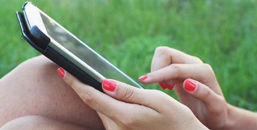 Mädchen benutzt Touchpad auf der Natur