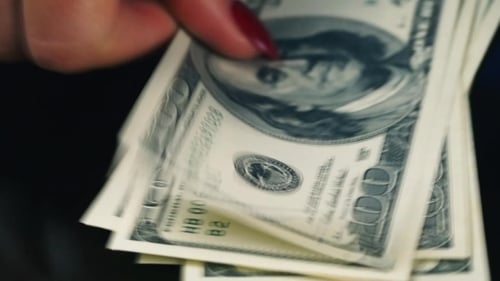 Hände verteilen Banknoten von hundert Dollar auf dem