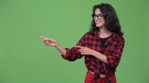 Smiling Woman Points to Left, Solid Green Backdrop