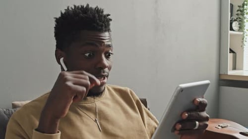 African American Man Chatting on Web Call on Tablet in Bedroom