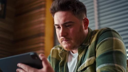 Man Smiling While Using Tablet Indoors