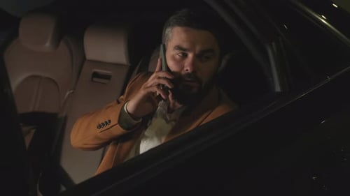Bearded Man on Phone Call in Car at Night