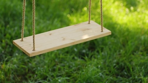 Balançoire en bois sur fond d'herbe verte