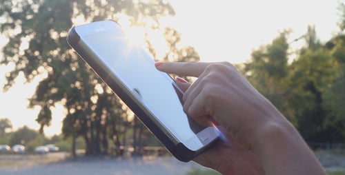 Mädchen im Park bei Sonnenuntergang und mit Tablet