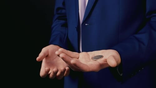 Zauberer zeigt einen Trick mit einer Münze