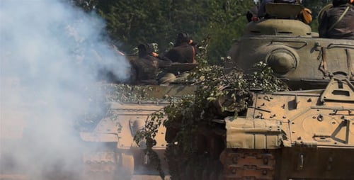 Tanks Maneuvering With Troops in Rural Landscape