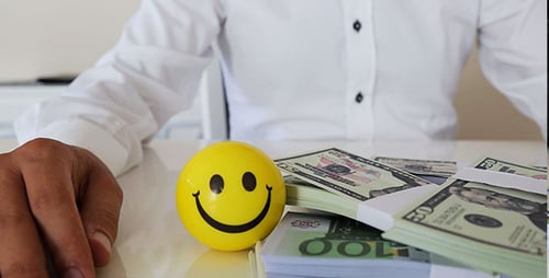 Stacks of Money and a Smiley Face Ball