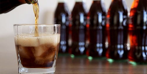 Refreshing Soda Being Poured into Iced Glass
