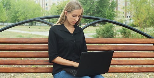 Beautiful Girl on Park Bench and Using Laptop