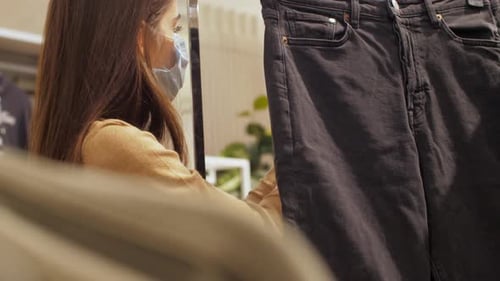 Woman Shops for Black Jeans Wearing Face Mask