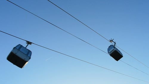 Gondola Cars Ascend Against a Clear Blue Sky
