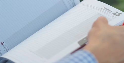 Man Writes In Notebook