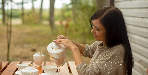 Women Enjoying Tea Outdoors in Rural Setting