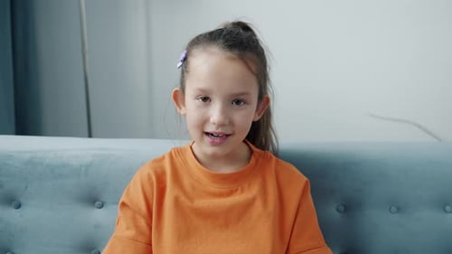 Smiling Girl Talks to Camera Indoors