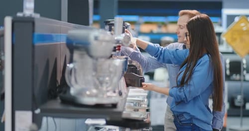 Young Beautiful Woman in the Appliances Store Is Choosing for Its Kitchen