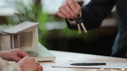 Business, Real Estate, Deal and People Concept - Man Giving House Keys To Woman at Office