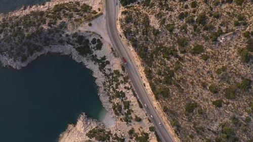 Aerial View of Cars Driving Through Scenic Sea and Mountains on a Summer Day