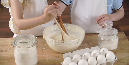 Children Mixing Batter Together in the Kitchen