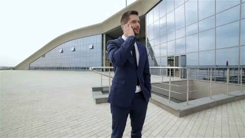 Man Talking on Phone Outside Modern Building