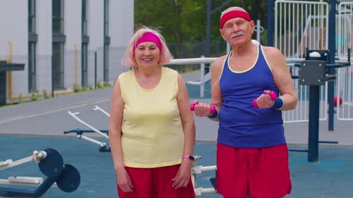 Senior Couple Exercises with Dumbbells Outdoors