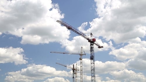 Construction Cranes Against a Bright Blue Sky