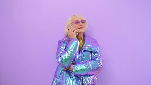 Senior Woman Talking on Phone in Shiny Jacket