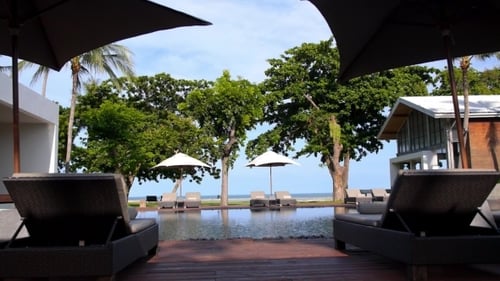 Resort Pool, Sunbed, Umbrellas Near The Sea