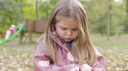 Cute Little Caucasian Girl is Sad As Her Mom is Angry at Her at a Playground Closeup