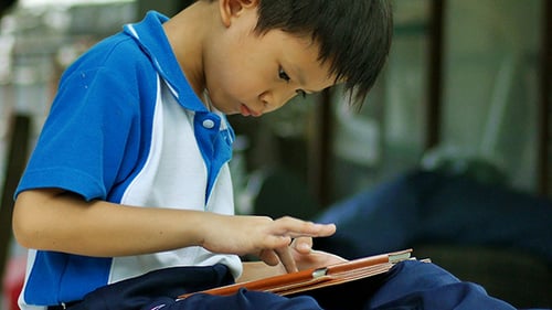 Child Plays on Digital Tablet at Home