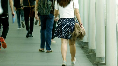 People Walking on Urban Sidewalk on Sunny Day