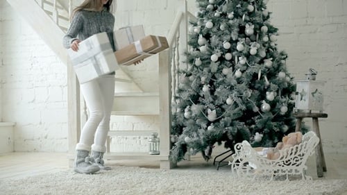 Woman Brings Christmas Presents Down Stairs