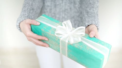Woman Holding Beautifully Wrapped Gift for Special Occasion