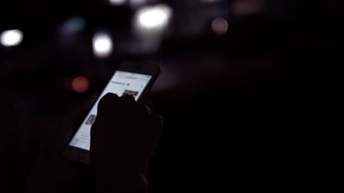 Hand Scrolling on a Phone at Night