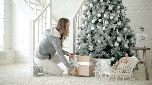 Woman Bringing Christmas Gifts Down Stairs