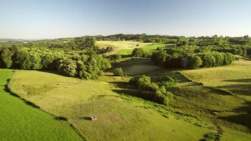 Aerial view of tractor harvesting straw bales in field, Correze, France.