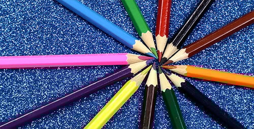 Vibrant Pencils Arranged on Blue Glittery Background