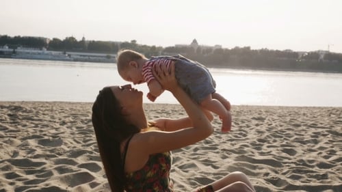 Mother Playing With Her Baby On The Beach