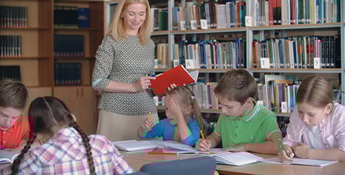 Teacher Assists Children with Schoolwork in Library