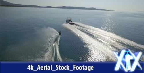 Water Skiing Behind Motorboat on Calm Blue Water